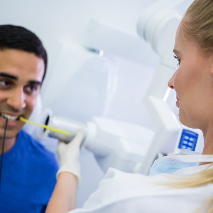 Female dentist taking x-ray of patients teeth at clinic