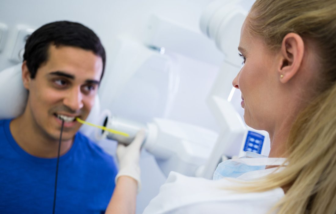 Female dentist taking x-ray of patients teeth at clinic