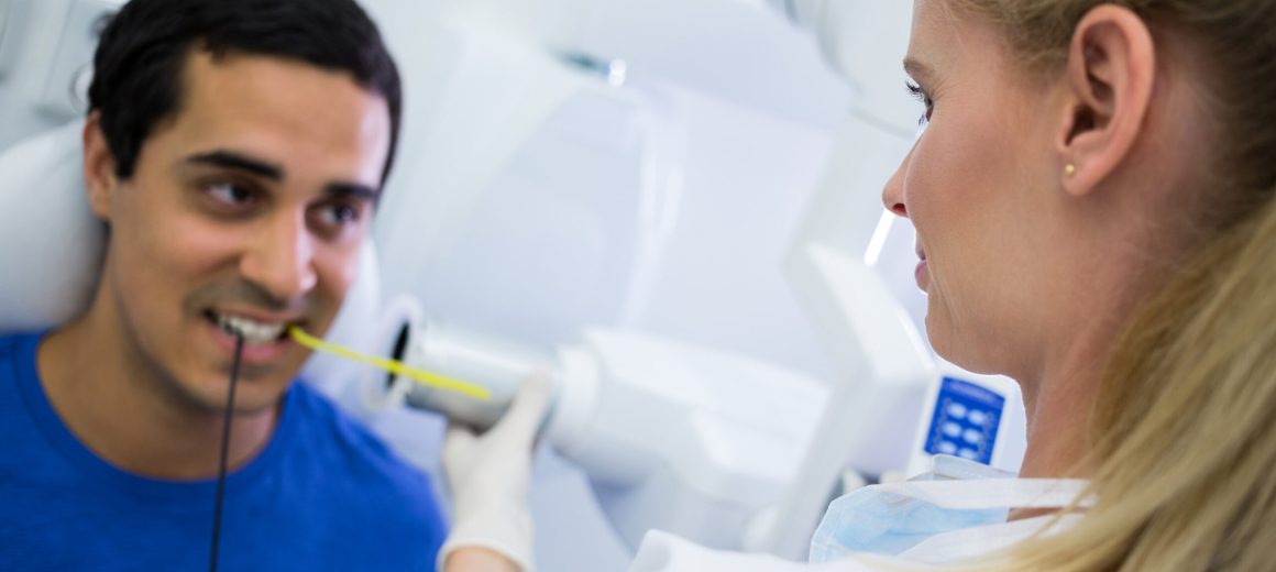 Female dentist taking x-ray of patients teeth at clinic
