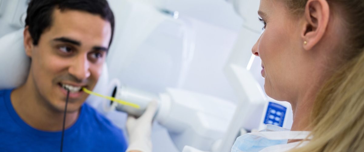 Female dentist taking x-ray of patients teeth at clinic